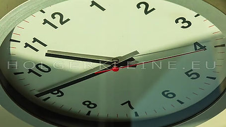 Close up to a wall clock, with running time pointer
